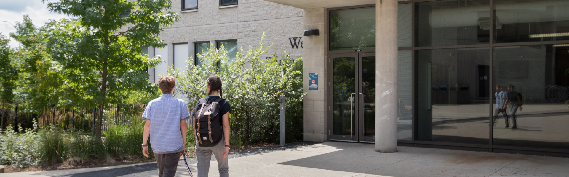 Two students walking towards the enterance of the Western Student Services Building