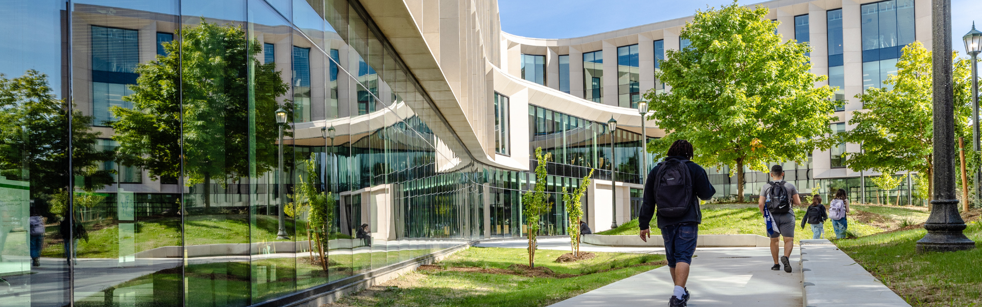 Students walking on campus in front of the Schmeichel Building for Entrepreneurship and Innovation