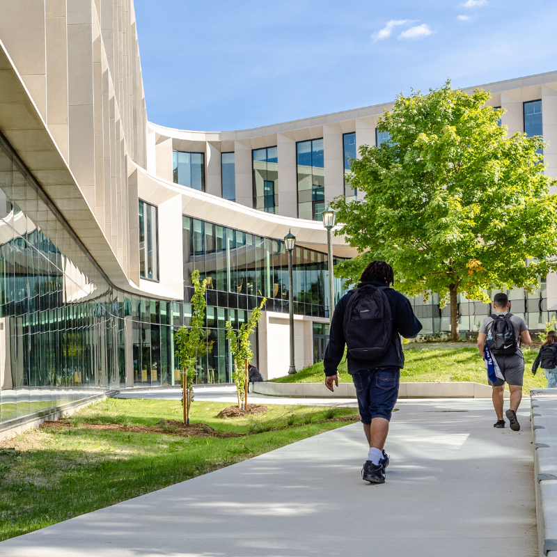 Students walking on campus in front of the Schmeichel Building for Entrepreneurship and Innovation