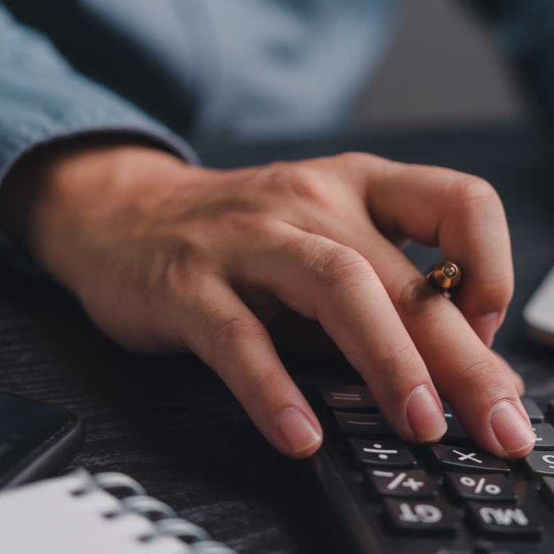 Student using a calculator and laptop to manage finances
