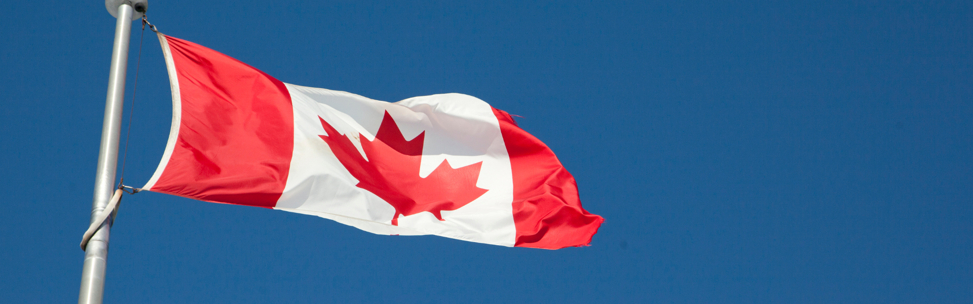 A Canadian flag flying on a flagpost