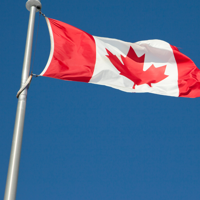 A Canadian flag flying on a flagpost