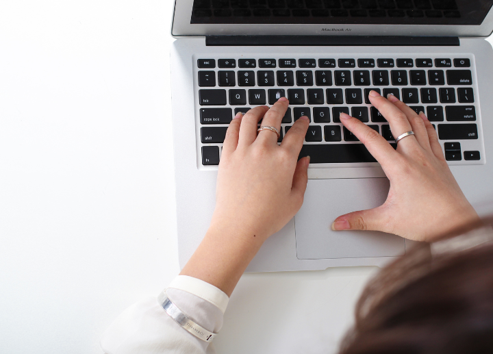Hands typing on a laptop