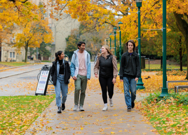 A group of students in backpacks walking together and talking