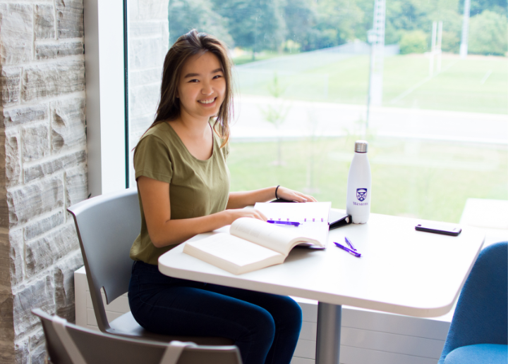A student studying at a desk on campus