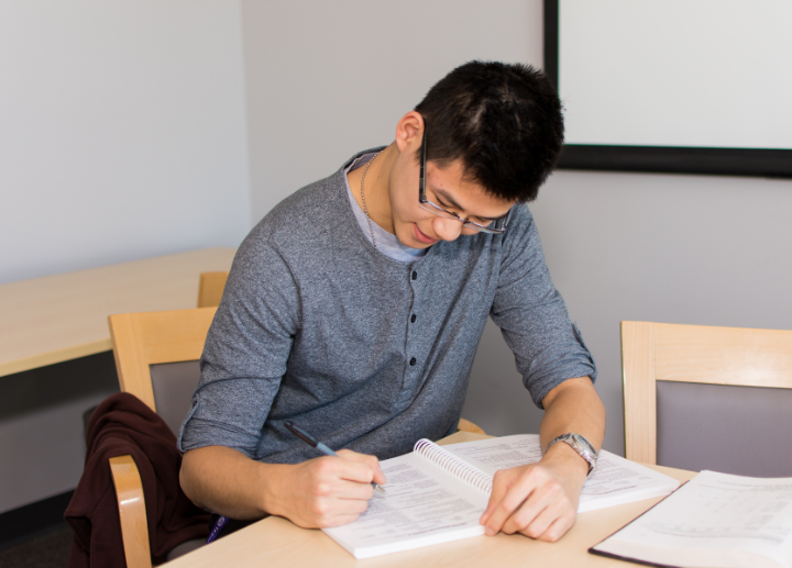 A student sitting at a desk doing course work