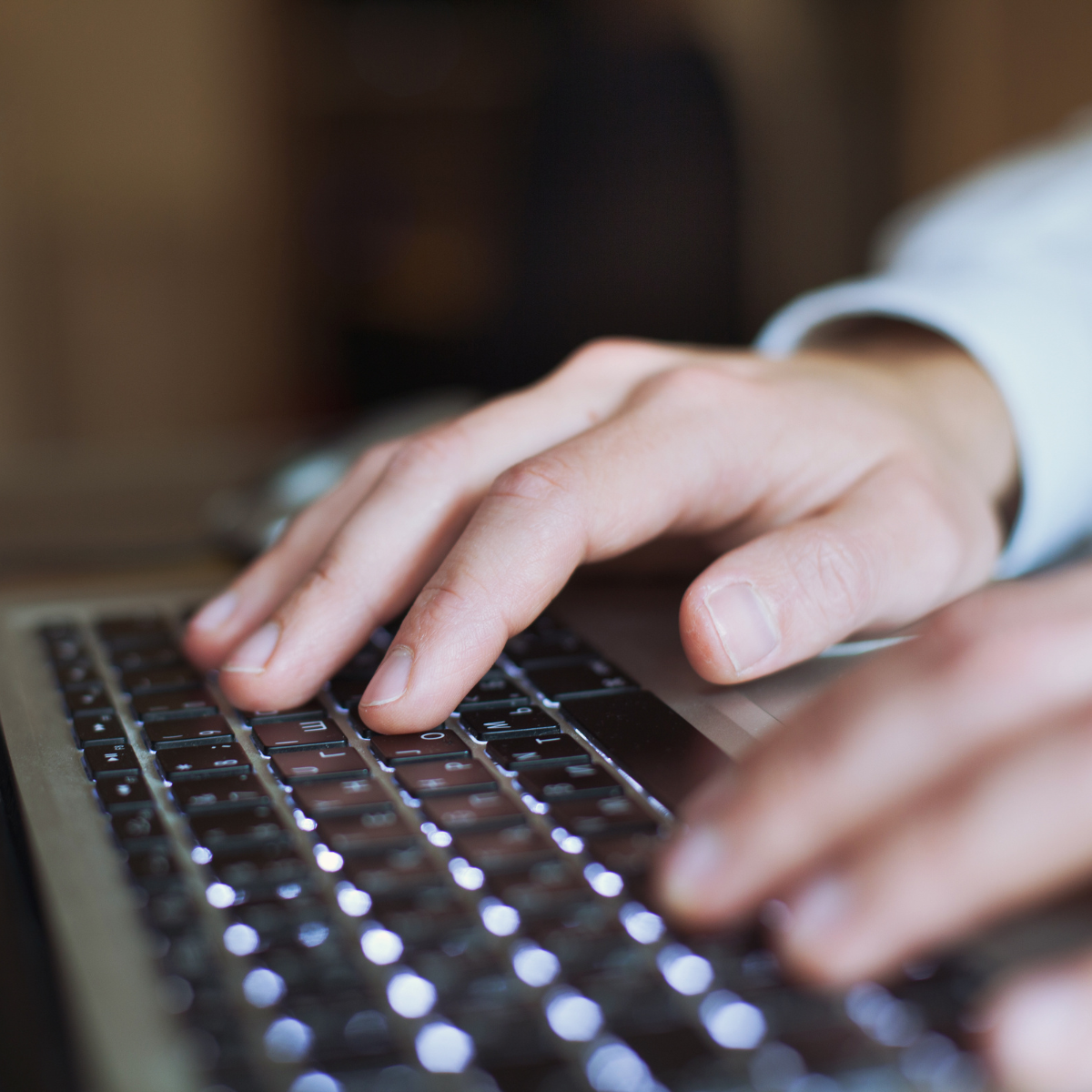 Hands typing at a computer
